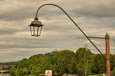 Turin, Piedmont, Italy. May 2019. The Basilica of Superga filmed by Piazza Vittorio. The green hills and a lamppost in the foreground are the settingのeditorial素材