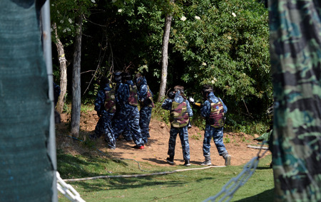 Battle at paintball. A small group of young players, fully equipped, are positioned to start the fight.の写真素材