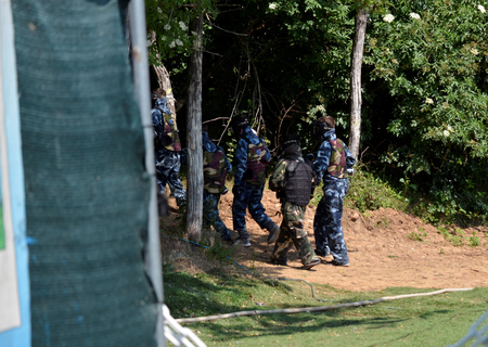 Battle at paintball. A small group of young players, fully equipped, are positioned to start the fight.の写真素材