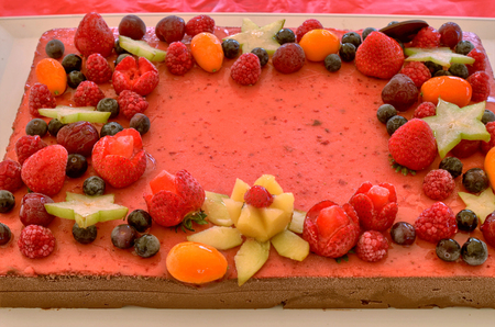 Appetizing fruit ice-cream cake decorated with strawberries, blueberries, cigliege, calamodino, kumquat, apple stars.の写真素材
