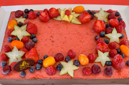 Appetizing fruit ice-cream cake decorated with strawberries, blueberries, cigliege, calamodino, kumquat, apple stars.の写真素材