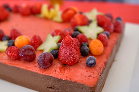Appetizing fruit ice-cream cake decorated with strawberries, blueberries, cigliege, calamodino, kumquat, apple stars.の写真素材