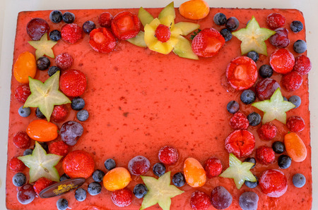 Appetizing fruit ice-cream cake decorated with strawberries, blueberries, cigliege, calamodino, kumquat, apple stars.の写真素材