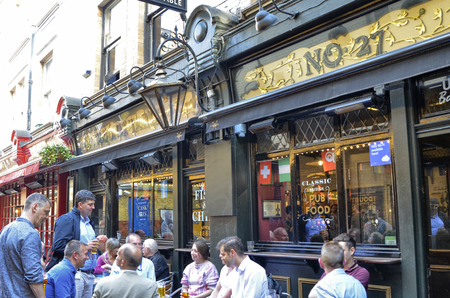 London, United Kingdom, June 14 2018. One of the many pubs in central London: friends meet to drink beer and eat something at all hours of the day.のeditorial素材
