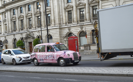 London, United Kingdom, June 2018. London taxis, called cabs. Traditionally of strictly black color, today they are seen with extravagant advertising colors. This case a nice rose!のeditorial素材