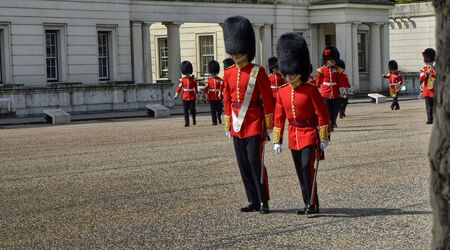 London, UK, June 2018. Along the Birdcage Walk in the Wellington Barracks courtyard, the royal guards prepare for the ceremonial of changing of the guard. Two guards in the foreground.のeditorial素材