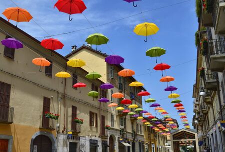 Turin, Piedmont, Italy. June 2019. Installation born with the street artists festival. Colored umbrellas, hanging between the houses along the alleys, give shade and joy with their bright colors.のeditorial素材