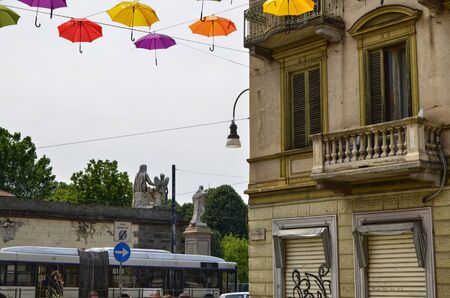 Turin, Piedmont, Italy. June 2019. Installation born with the street artists festival. Colored umbrellas, hanging between the houses along the alleys, give shade and joy with their bright colors.のeditorial素材