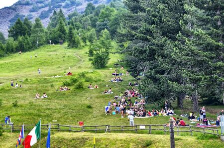 Colle del Lys, Piedmont, Italy. July 2019. People looking for refreshment take advantage of the slope of the mountain with a large green lawn to picnic. The passage of clouds is recognizable.のeditorial素材