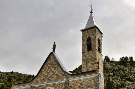 Sant'Anna di Vinadio, Piedmont, Italy. July 2019. Detail of the facade of the Sanctuary. Rainy day with dark clouds.の写真素材