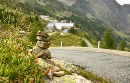 Stones stacked as a Zen memorial along a mountain road, a township in the background blurred and indistinguishable.の写真素材
