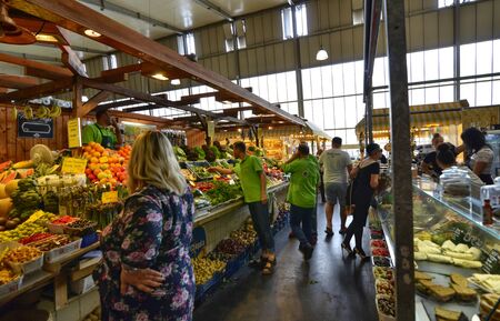 Frankfurt am Main, Germany. August 2019. All kinds of fresh goods are on display at the central covered market, the Kleinmarkthalle. People observe the desks with interest.のeditorial素材