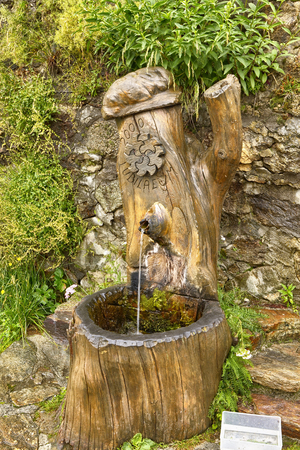 S. Anna di Vinadio, Piedmont, Italy. July 2019. A drinking water fountain made of artistically carved wood.のeditorial素材