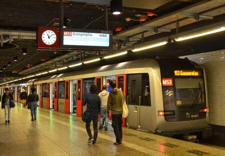 Amsterdam, Netherlands. August 2019. The underground part of the metro: modern and bright, teeming with people from all ethnic groups. A train is stopped at the dock.のeditorial素材