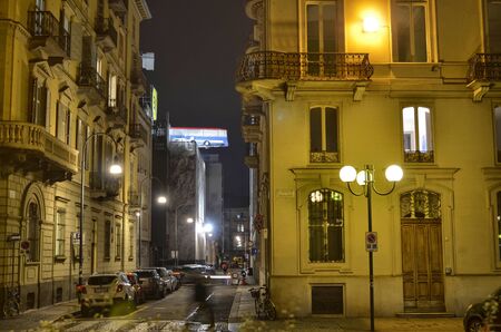 Turin, Piemonte, Italy. November 2019. A bus poised on the roof of a building. You can see the bus swinging slowly. It is an artistic installation in homage to the movie The Italian Job. Night shot.のeditorial素材
