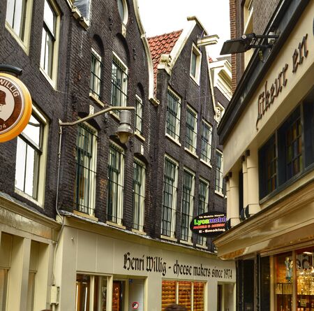 Amsterdam, Holland, August 2019. The alleys of the old town on a rainy day. The houses look a bit gloomy but the tourists are always present.のeditorial素材