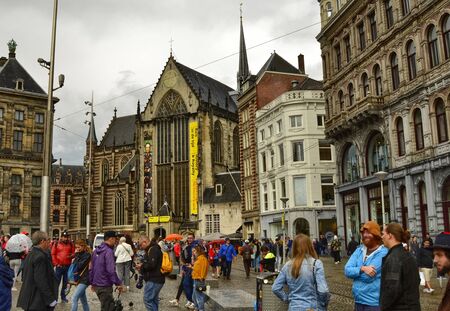 Amsterdam, Holland. August 2019. Dam Square, the historic heart of the city, the new church is facing. A lot of tourists crowd the square despite the rainy day.のeditorial素材