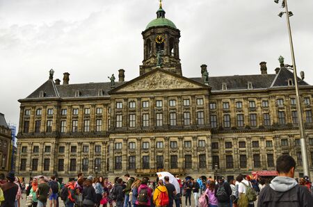 Amsterdam, Holland. August 2019. Dam Square, the historic heart of the city, faces the royal palace. A lot of tourists crowd the square despite the rainy day.のeditorial素材
