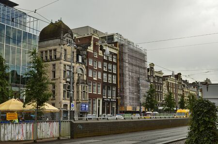Amsterdam,Holland.August 2019.The historic center is characterized by the appearance of the typical houses on the street. They are kept in perfect condition with maintenance work: scaffolding visibleのeditorial素材