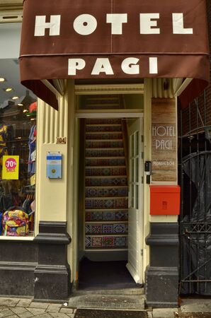 Amsterdam, Holland. August 2019. In the historic center, the entrance to a hotel. The steep staircase with brightly colored steps features.のeditorial素材