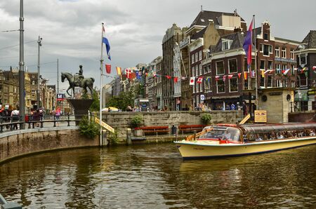 Amsterdam, Holland. August 2019. The large tourist boats that crowd the canals of the historic center: they move all day transporting large numbers of visiting tourists.のeditorial素材