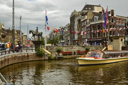 Amsterdam, Holland. August 2019. The large tourist boats that crowd the canals of the historic center: they move all day transporting large numbers of visiting tourists.のeditorial素材