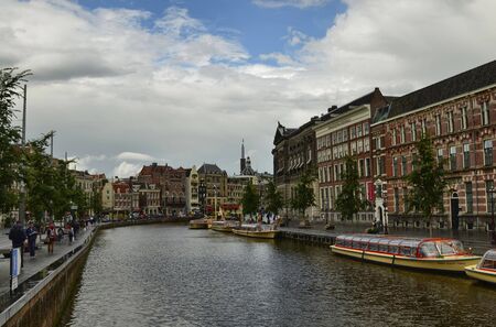 Amsterdam, Holland. August 2019. The large tourist boats that crowd the canals of the historic center: they move all day transporting large numbers of visiting tourists.のeditorial素材