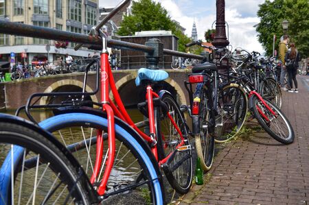 Amsterdam, Holland. August 2019. Bicycles parked along the canals are a symbol of the city. A bike with a red racing frame stands out among the others.のeditorial素材