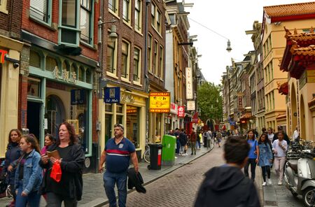 Amsterdam, Holland, August 2019. Amsterdam's cinatown is immediately recognizable by its ideograms and unmistakable architecture. People walk down the street.のeditorial素材