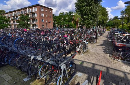 Amsterdam, Holland, August 2019. In the modern suburbs a large outdoor parking for bicycles. Thanks to two-level racks you can park a significant amount of two wheels.のeditorial素材