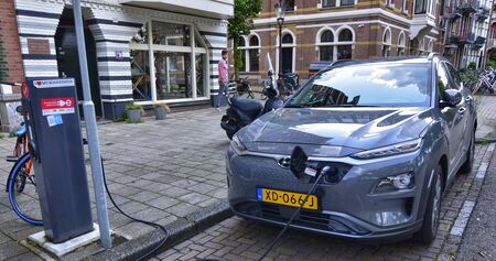 Amsterdam, Holland, August 2019. Along the Amstel river, an electric car is being charged: the cable...