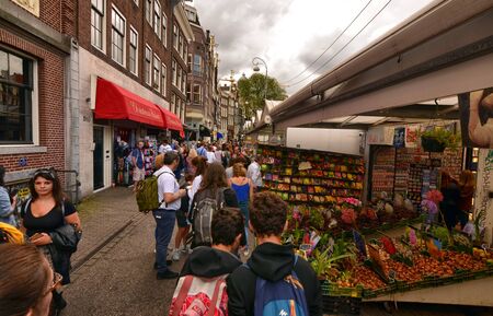 Amsterdam, Holland, August 2019. At the flower market, tourists walk along the sequence of exhibitor benches. A large variety of bulbs is available.のeditorial素材