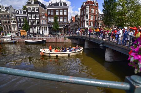 Amsterdam, Holland, August 2019. The bridges over the canals are a reference point for tourists to take souvenir photos. On the railings planters to embellish and parked bikes.のeditorial素材