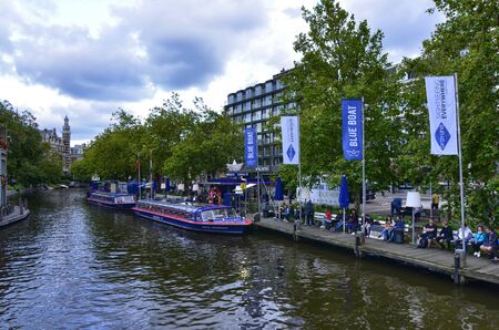 Amsterdam, the Netherlands, August 2019. On the right, along the canal bank, a landing place for the Blue Boat Company: a tourist boat company to visit the city.のeditorial素材