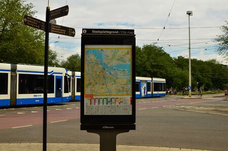 Amsterdam, the netherlands, august 2019. A tram: in this city they are characterized by white and blue colors. They pass very frequently in the streets of the center. The city map in the foreground.のeditorial素材