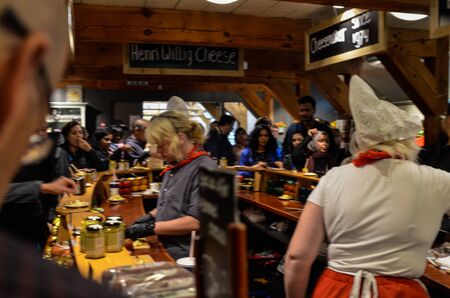 Zaanse Schans, Holland, August 2019. Tasting of typical Dutch cheeses: along the counter there are saucers with cubes of cheese to taste, people flock to taste. Women in typical Dutch costume.のeditorial素材