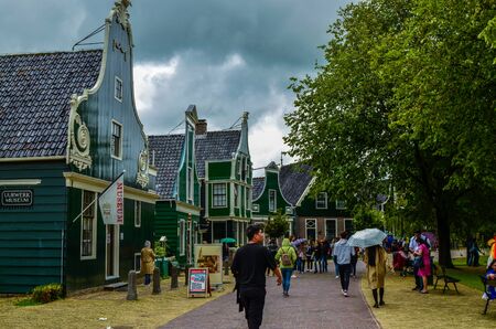 Zaanse Schans, Holland, August 2019. Northeast Amsterdam is a small community located on the Zaan River. View of the pretty wooden houses of the village, mainly green in color. Cloudy day.のeditorial素材