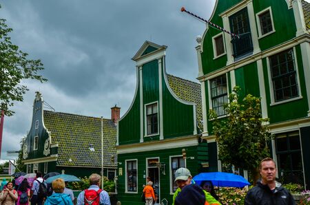 Zaanse Schans, Holland, August 2019. Northeast Amsterdam is a small community located on the Zaan River. View of the pretty wooden houses of the village, mainly green in color. Cloudy day.のeditorial素材