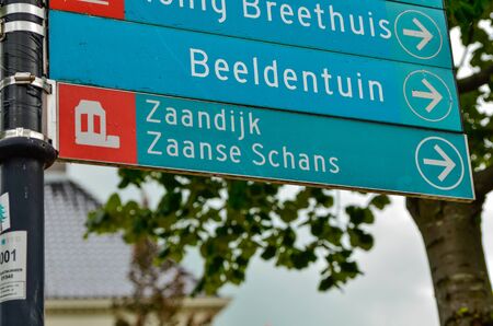Zaandijk, Holland, August 2019. Northeast Amsterdam is a small community located on the Zaan River. A road sign indicates the tourist resort of the mills: Zaanse Schans.のeditorial素材