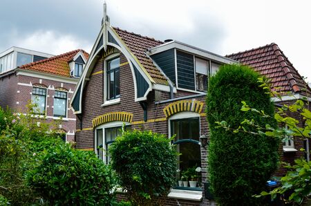 Zaandijk, Holland, August 2019. Northeast Amsterdam is a small community located on the Zaan River. An example of the pretty houses in this village: red brick and a small garden with shrubs.のeditorial素材