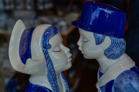 Delft, the netherlands, august 2019. The couple kissing at a shop of the famous white and blue ceramics: a very appreciated and famous souvenir.のeditorial素材