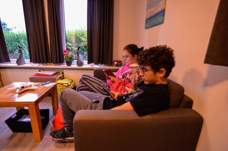 Goes, the netherlands, august 2019. At a campsite a nice white bungalow. Inside, overlooking the comfortable lounge, guests relax.のeditorial素材