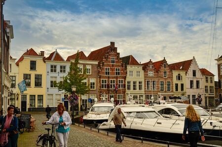 Goes, the netherlands, august 2019. View of the small and pretty harbor. It creeps between the historic houses of the center, along the piers trees and lampposts with planters.のeditorial素材