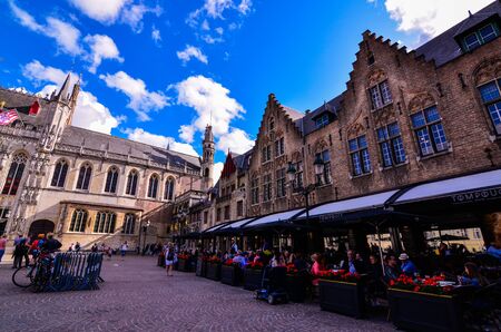 Bruges, Flanders, Belgium.August 2019. Burg square is one of the most important. The splendid town hall overlooks it together with the characteristic architecture buildings. A restaurant with plantersのeditorial素材
