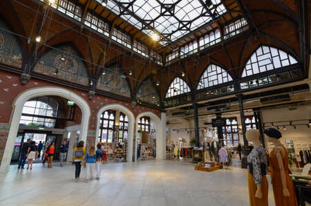 Ghent, Belgium, August 2019. The Post is a boutique hotel based in the former post office, an emblematic historical building in the center. People walk in the large living room indoors. Glazed canopy.のeditorial素材