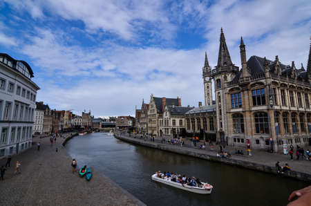 Ghent, Belgium, August 2019. Breathtaking cityscape: from the St. Michael's bridge to the street along the Graslei canal. One of the most beautiful postcards in the city. People stop to watch.のeditorial素材