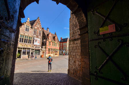 Ghent, Belgium, August 2019. The Gravensteen is the castle of the counts of Flanders. View from inside the walls towards the outside: on the square the characteristic red brick houses and people.のeditorial素材