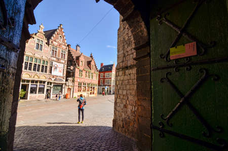 Ghent, Belgium, August 2019. The Gravensteen is the castle of the counts of Flanders. View from inside the walls towards the outside: on the square the characteristic red brick houses and people.のeditorial素材