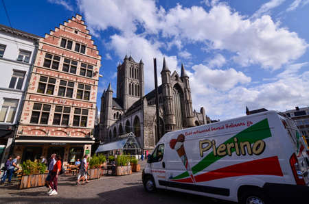 Ghent, Belgium. August 2019. The Church of San Nicola overlooks the historical center of the center, the Korenmarkt. An ice cream van on the right, people walking in the street.のeditorial素材