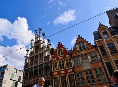 Ghent, Belgium. August 2019. Historical buildings with rich finishes overlook the historic center square, the Korenmarkt. On the left the facade of a building is surmounted by statues on thin columns.のeditorial素材